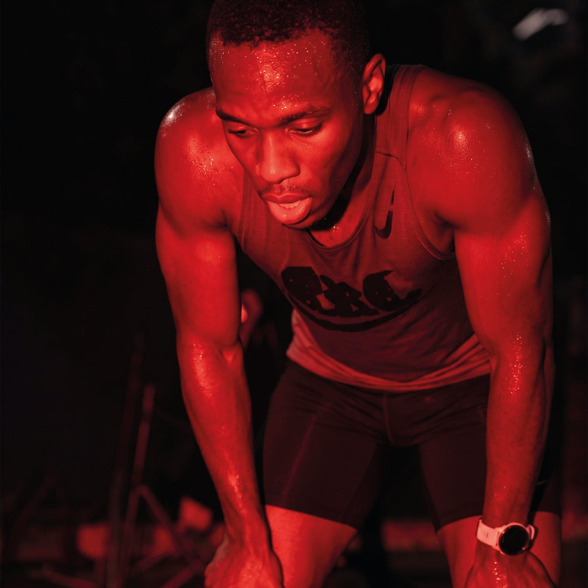 Exhausted athlete resting with hands on knees after a workout